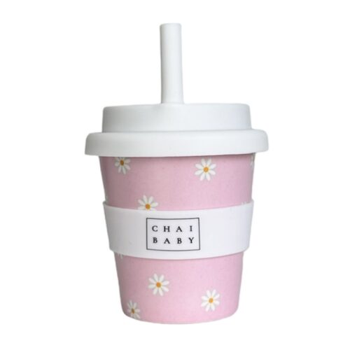 A babyccino cup made of bamboo with a pink background and white flowers with a silicone lid, band and straw